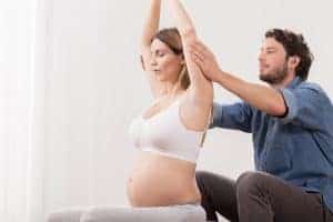 husband helping pregnant wife get ready for labor
