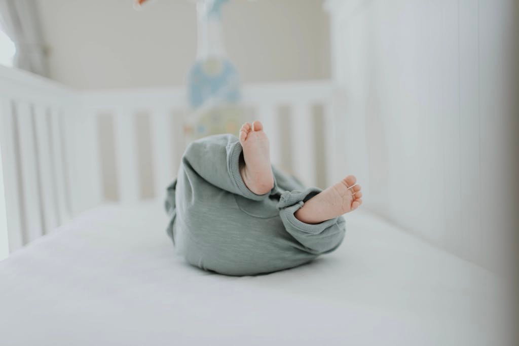 Cute baby feet in pajamas on a soft white crib. Perfect for children's room decor.